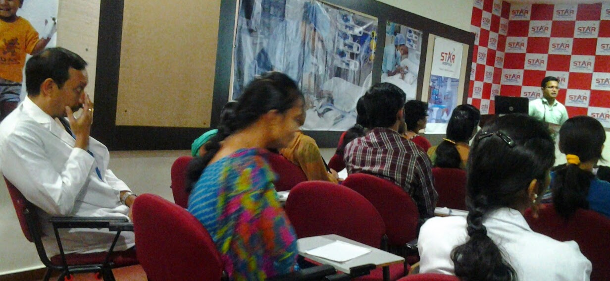 Dr. Suresh addressing physicians in white coats at Star Hospitals CME